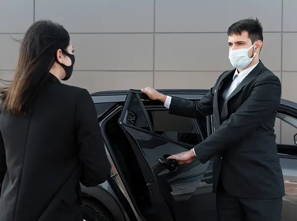 Chauffeur opening vehicle door for a guest